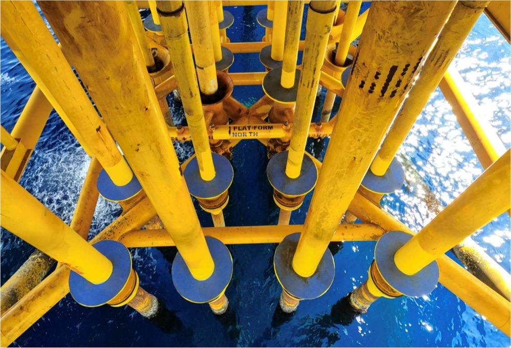 Row of conductor and riser guides viewed from above an offshore platform
