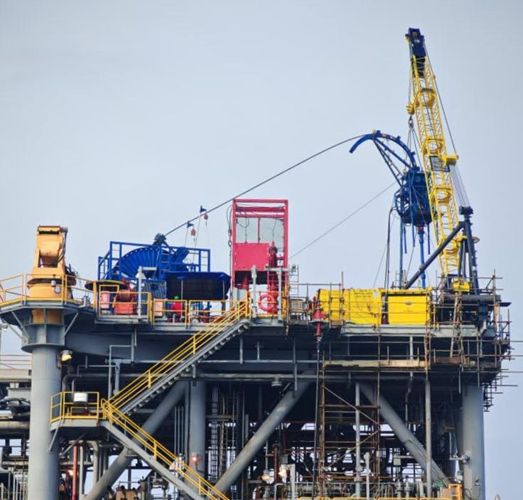 Yellow offshore pedestal crane on a topside maintenance platform